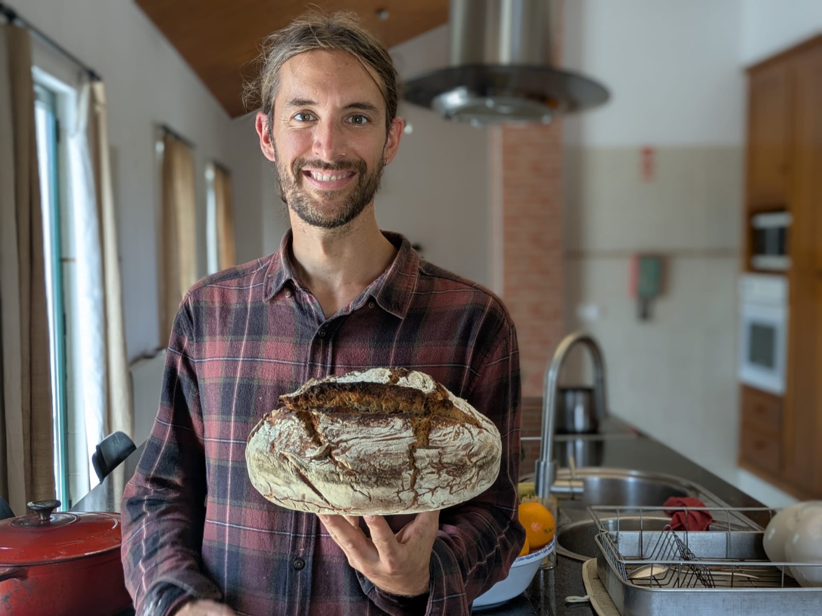 Portrait of Chris holding a fresh loaf of homemade bread
