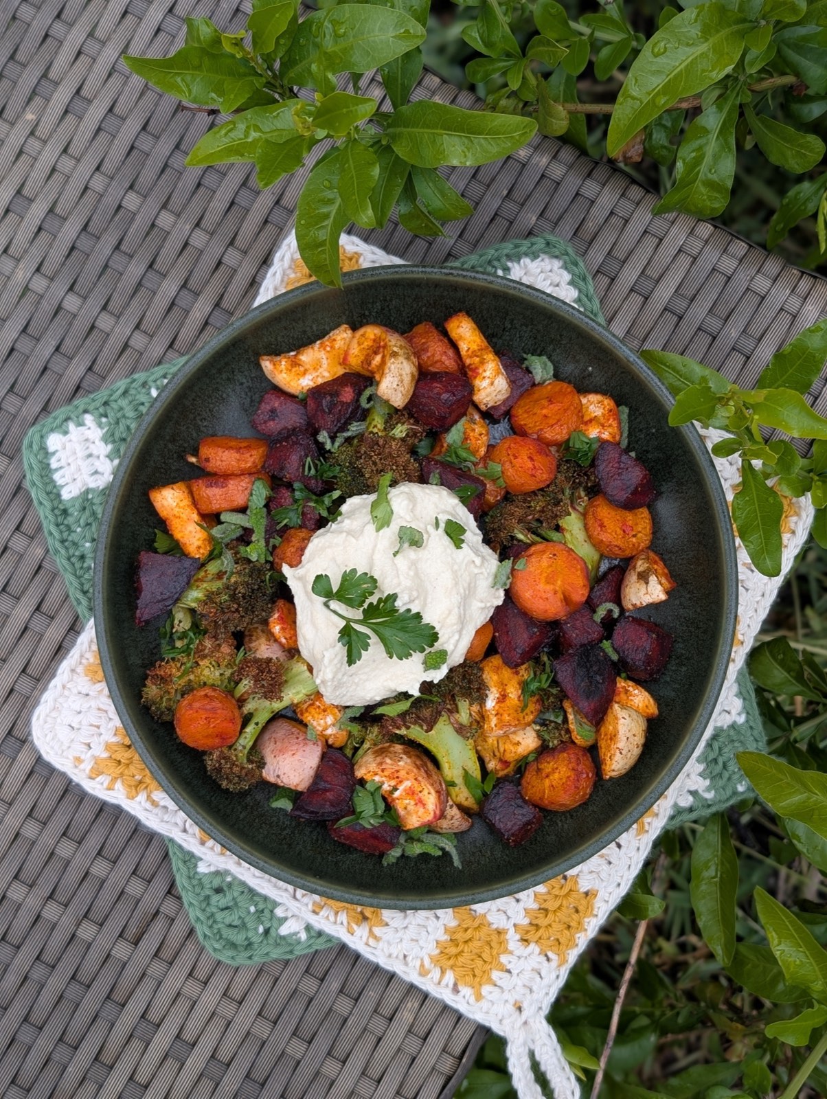A bowl of roasted vegetables topped with whipped hummus
